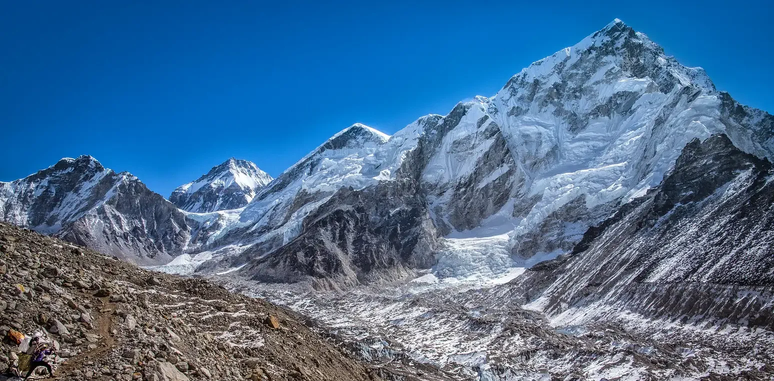 Stunning view of the Khumbu Icefall with towering peaks and rocky terrain, showcasing the route to Camp 1 on Mount Everest's south side.